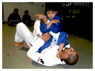 Kid Power student in a Brazilian Jiu Jitsu exercise with instructor